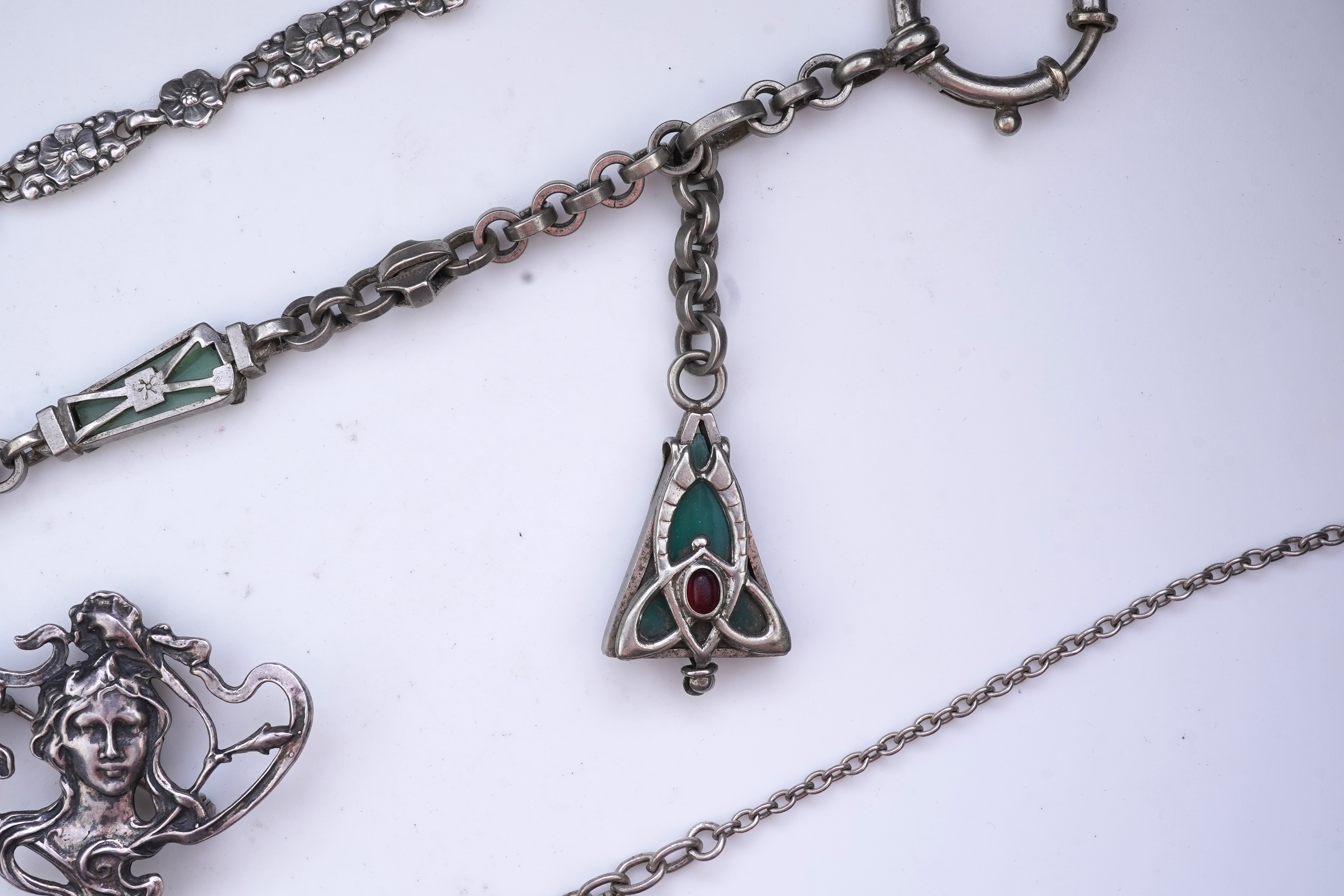 A collection of three silver chains and an Art Nouveau brooch, early 20th century
